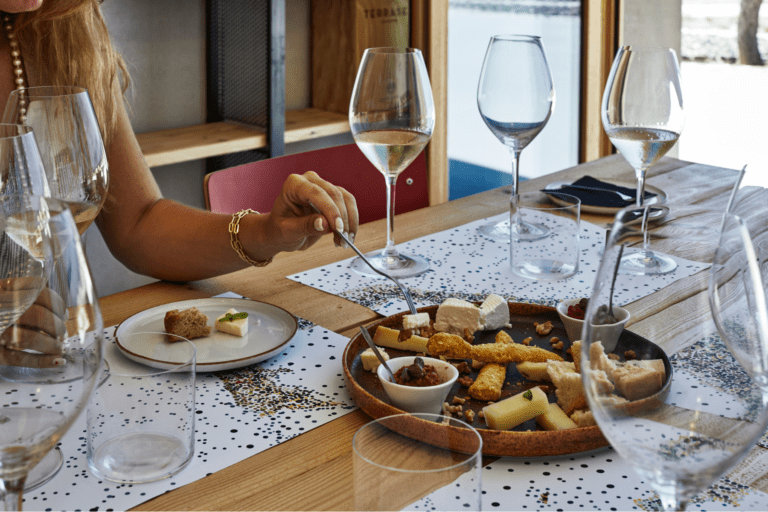 A person samples cheese and wine at Mikra Thira winery on Santorini.