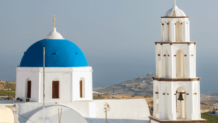 Blue-domed church and bell tower in Pyrgos village, Santorini.
